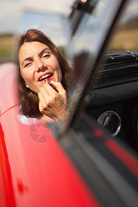 在汽车镜上涂口红的女人图片