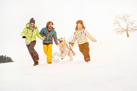 一家人和狗在雪上奔跑外国儿童高清图片素材