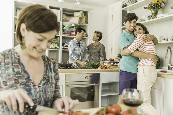五个成人朋友在厨房准备食物和聊天图片