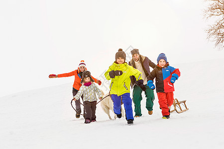 雪地里奔跑的家庭帽子高清图片素材