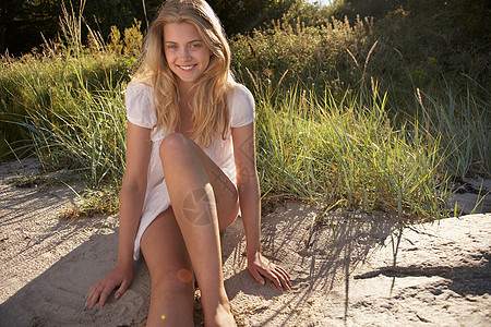 坐在海滩边的年轻女子背景图片