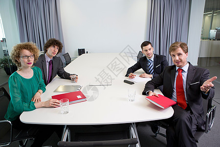 商务人士坐在会议桌旁做文书工作图片