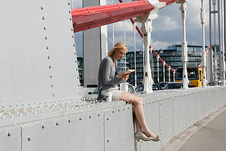 坐在桥上看书的女人图片
