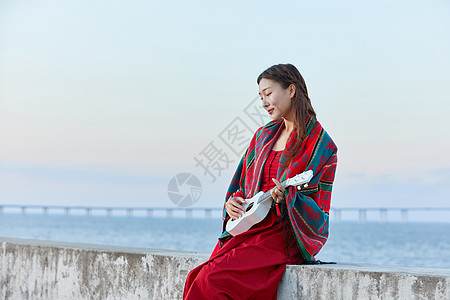 女孩谈尤克里里文艺女生海边谈尤克里里背景