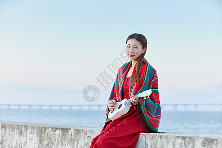 女孩谈尤克里里文艺女生海边谈尤克里里背景