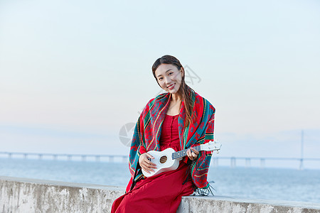 女孩谈尤克里里文艺女生海边谈尤克里里背景