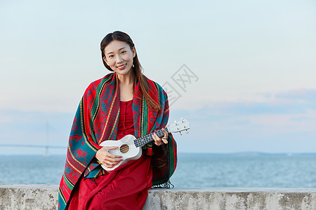 素材尤克里里文艺美女海边弹尤克里里背景