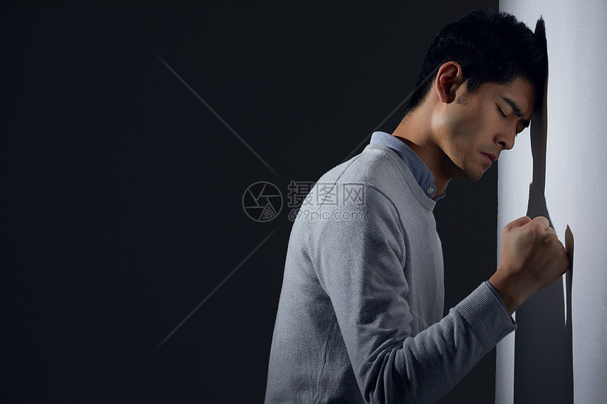 青年男性痛苦面对墙壁