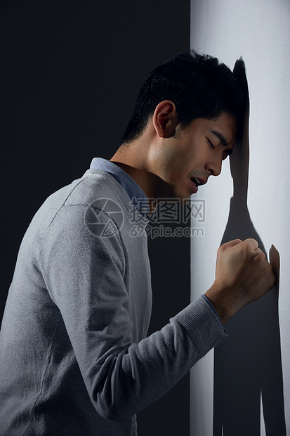 青年男性痛苦面对墙壁