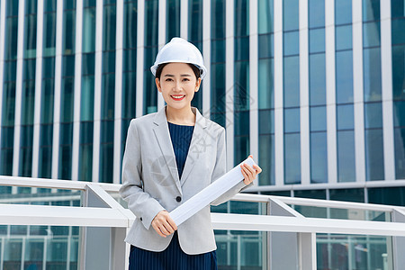 女性建筑工程师拿图纸背景图片