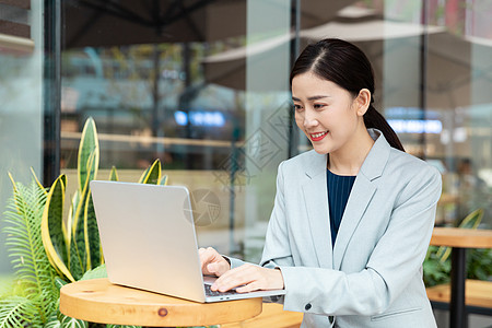 商务人商务女性在咖啡厅用笔记本电脑办公背景