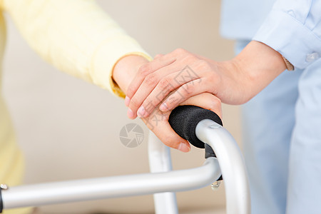 护工扶着使用健步器的老奶奶锻炼身体特写图片