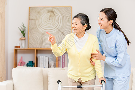 护工扶着使用健步器的老奶奶锻炼身体高清图片