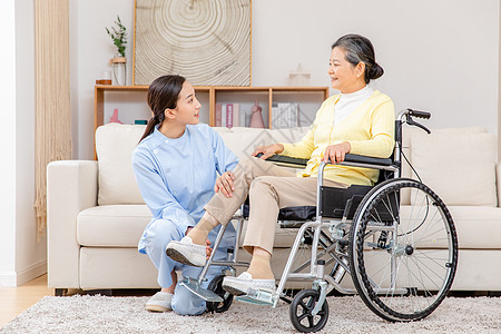 腿部穴位护工为坐在轮椅上的老奶奶腿部按摩背景