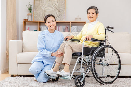 护工为坐在轮椅上的老奶奶腿部按摩图片