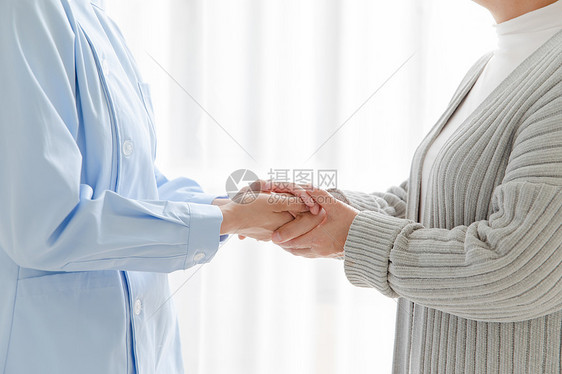家庭护士和老人握手图片