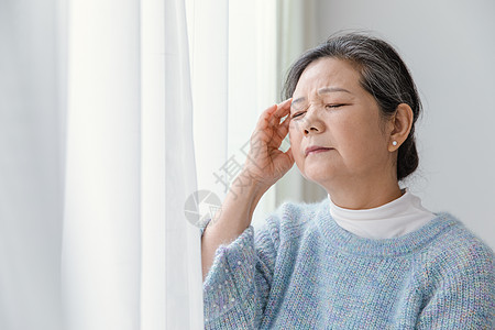 靠在窗边头疼的女人高清图片