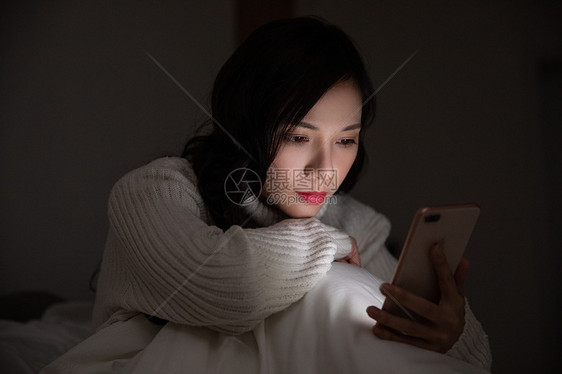 青年女性夜晚熬夜玩手机图片