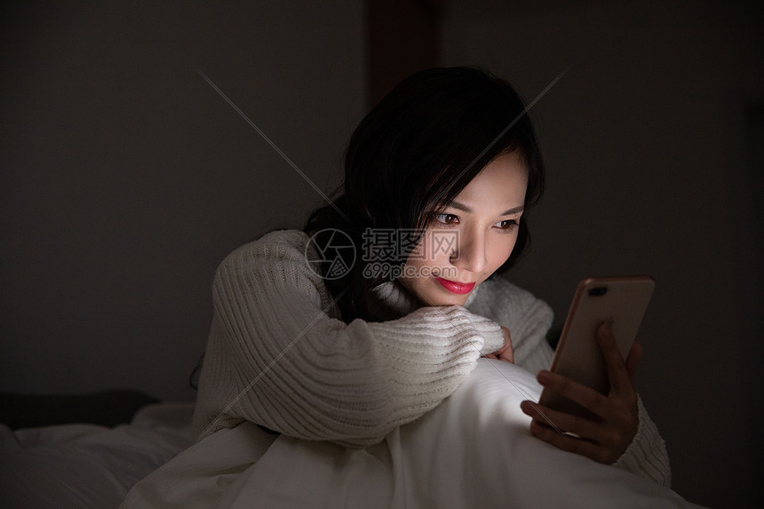 青年女性夜晚熬夜玩手机图片