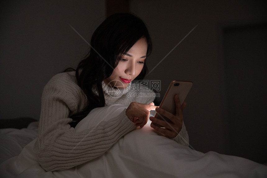 青年女性夜晚熬夜玩手机图片