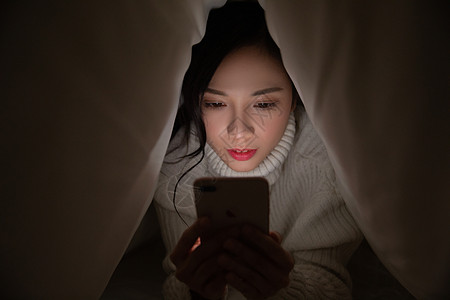 青年女性被窝熬夜玩手机图片素材