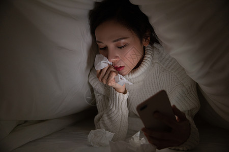 青年女性深夜看手机流泪背景