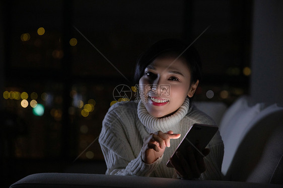冬季青年女性夜晚玩手机图片