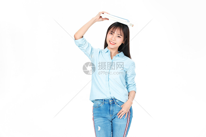 成人教育美女大学生拿书顶头上图片