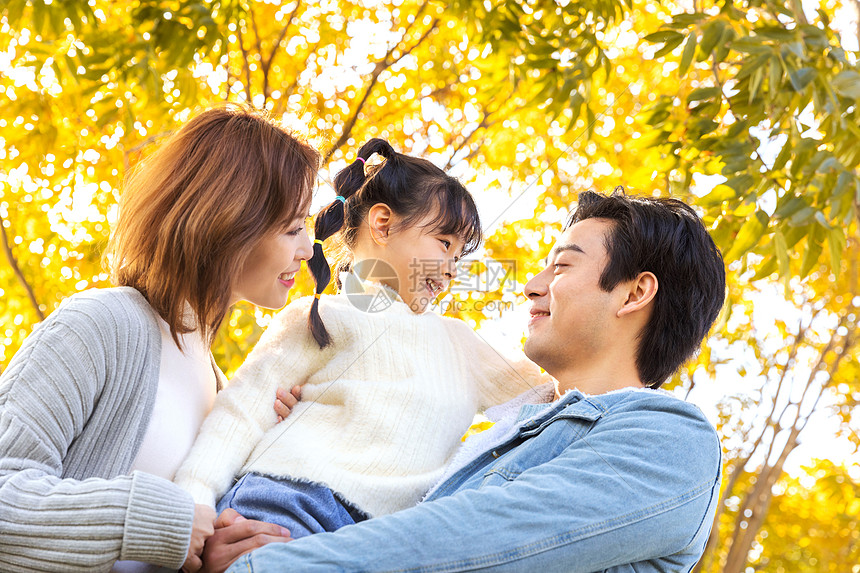 爸爸妈妈抱着女儿在公园玩耍