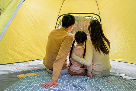 一家人坐着一家三口坐在帐篷里背景