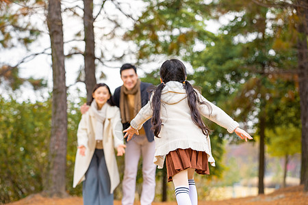 年轻妈妈年轻爸妈向女儿张开怀抱背景