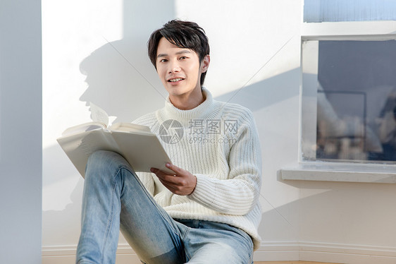 坐在阳台看书的男青年图片