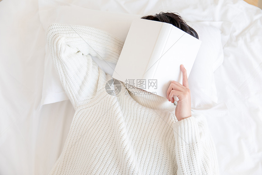 居家男性躺在床上用书盖着脸图片
