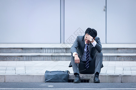 坐在路边崩溃伤心的商务男性高清图片