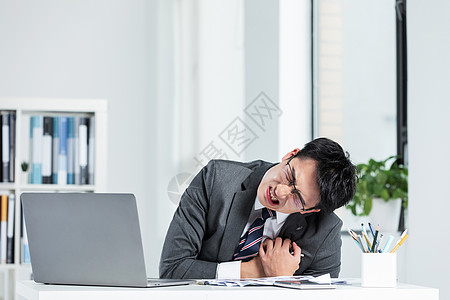 工作劳累心脏疼痛的商务男性图片