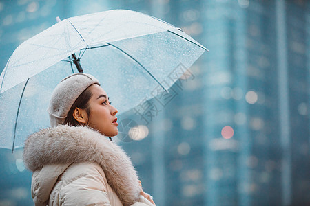 雨伞美女冬季女性户外下雨天撑伞看远方背景