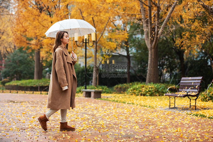 秋季雨天美女撑伞公园散步图片