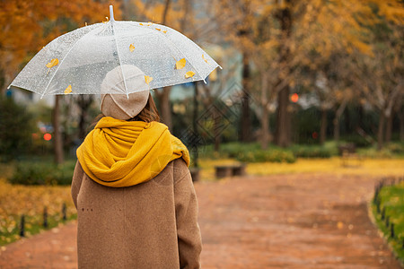 雨伞美女下雨天美女公园里散步背景