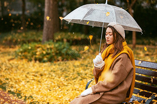秋季银杏树下悲伤美女撑伞图片