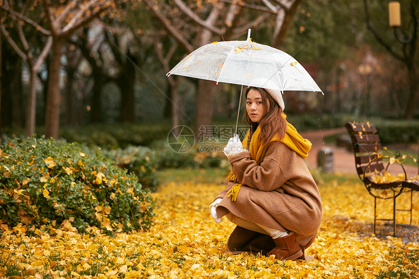 秋季银杏树下悲伤美女撑伞图片