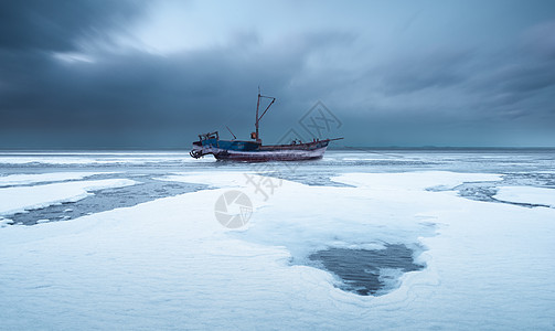 窗外大雪海面结冰停泊的渔船背景