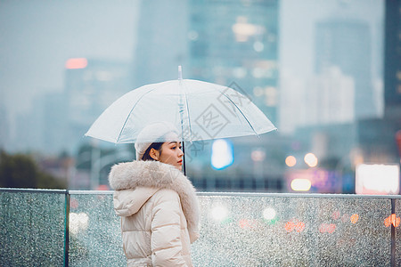 雨中行走的人冬季户外孤单女性撑伞背景