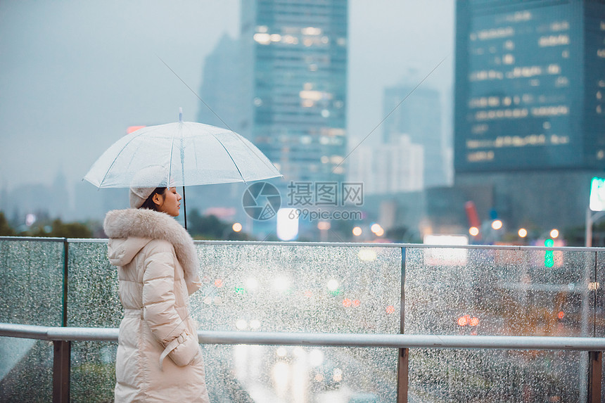 冬季户外孤单女性背影撑伞图片