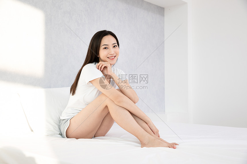 青年居家女性坐在床上休息图片