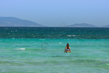 蓝色的爱琴海海滨沙滩休闲度假游泳女人背影图片