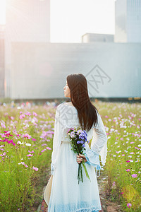 花海少女手拿花束背影图片