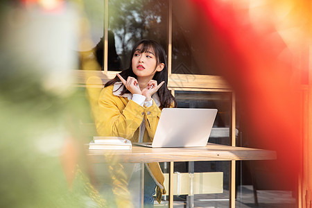 咖啡厅内景坐在咖啡厅使用笔记本的女大学生背景