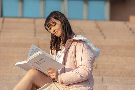 高中女孩在校园台阶上看书的大学生背景