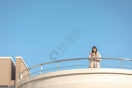 咋骗通知趴在天台栏杆前的甜美女孩背景