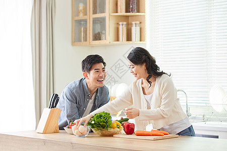 居家情侣年轻夫妻在厨房一起备菜背景